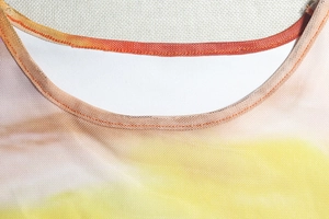 Detailaufnahme des Rundhalsausschnitts mit feinen Nähten am Kleid mit Farbverlauf