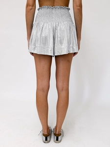 Macro detail of metallic silver shorts showing elastic waist and shiny fabric texture