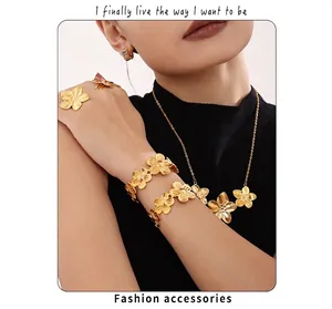 Detailed view of model wearing gold flower jewelry set with necklace and ring