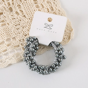 Detail shot of grey faux pearl elastic hair tie with metallic finish on handmade card