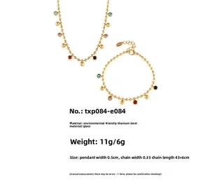 Détail de parure en titane plaqué or 18k avec pendentifs ronds en verre coloré
