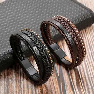 Detail of multi-layer braided leather bracelets with metal rivets and magnetic clasp