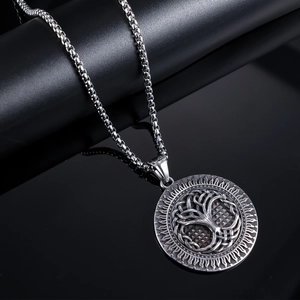 Macro detail of silver Tree of Life pendant with intricate sunburst texture and box chain
