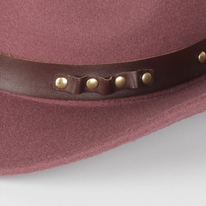 Detail of dusty rose wool fedora showing brown leather band with gold rivet studs