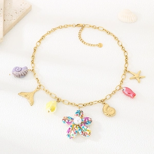 Detail of 18k gold chain necklace with starfish shell and pearl pendants for summer beach