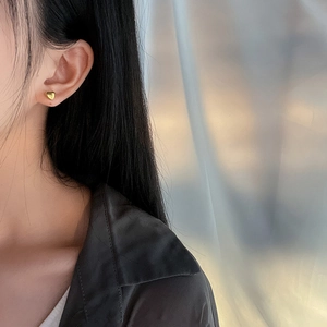 Poliert 18K vergoldete Herz-Ohrstecker am Model für einen eleganten minimalistischen Stil