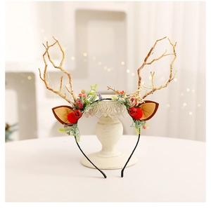 Detail of DIY Christmas reindeer antler headband with bells and faux greenery decor