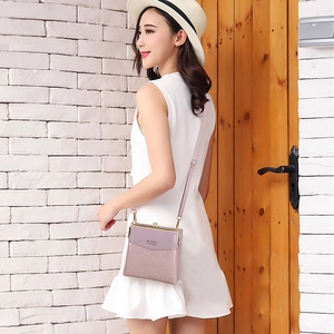 Purple faux crocodile texture crossbody bag with metal clasp shown in a street scene