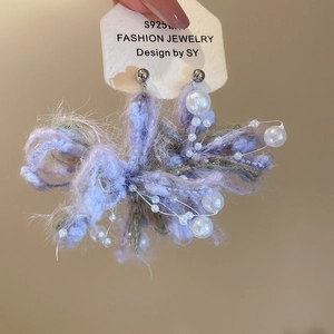 Detail of purple knitted flower earrings with faux pearls on S925 silver studs