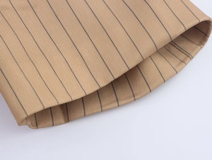 Detailed close-up of dark khaki striped linen blend fabric with refined stitching and texture
