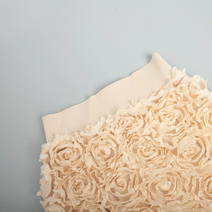 Detailed close-up of 3D mesh rose petals and elastic waistband on beige evening skirt