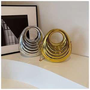Detailed close-up of metallic acrylic box bags with wavy textures in gold and silver
