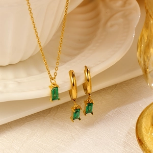 Elegant gold jewelry set with emerald green rectangular gemstone earrings and necklace