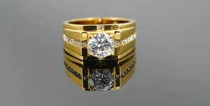 Macro detail of men's gold titanium ring featuring a large center stone and pavé accents