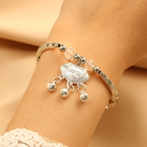Detailed view of silver long life lock bracelet with clear crystal beads and bells
