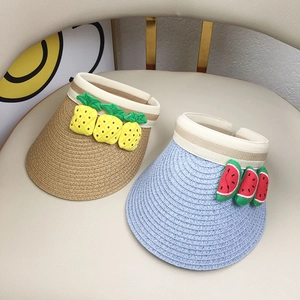 Detail of straw woven sun visors with 3D pineapple and watermelon fruit decor