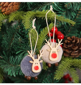 Close-up of grey and off-white felt elk ornaments hanging on a festive Christmas tree