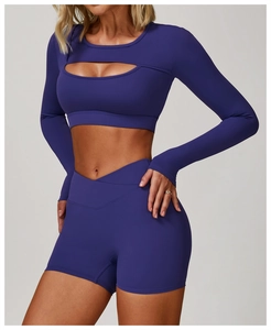 Détail d'un haut de yoga violet foncé avec découpes évidées et short à taille croisée assorti