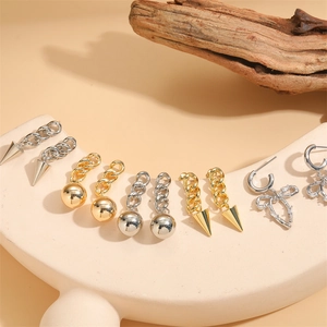 Set di orecchini a fiocco e cono geometrico placcati oro 14K su scena decorativa