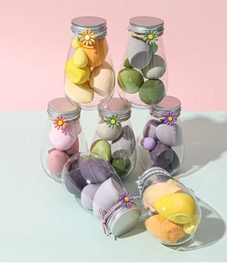 Detailed view of colorful makeup sponge sets in glass jars with floral decorations