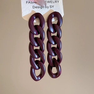 Macro view of long dark purple acrylic chain earrings with matte finish on display card