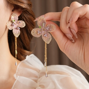 Detail of vintage pink flower earrings with purple tassels and gold crystal beads