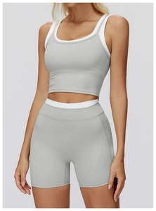 Detail eines grauen Yoga-Sets mit weißen Kontraststreifen und High-Waist Radlerhosen-Schnitt