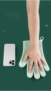 Detail of light green heat-resistant silicone oven glove with heart-shaped non-slip patterns
