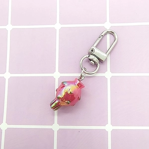 Close-up of pink metallic jellyfish keychain with silver lobster clasp on grid background