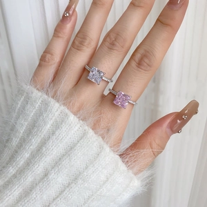 Macro shot of square-cut pink and clear zircon rings with micro-paved bands on a model