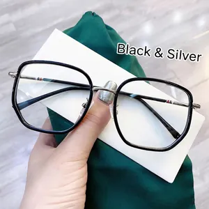 Detail of black and silver oversized glasses frame with striped metal temples on silk