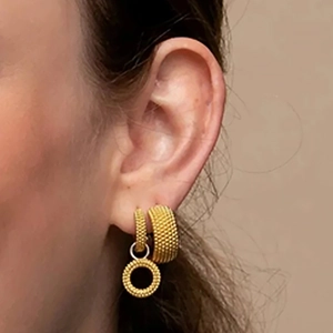 Detail of 925 silver gold-plated textured hoop earrings on model ear lobe