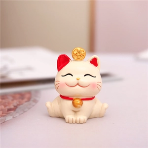 Close-up of a lucky cat ornament with a golden bell and a traditional coin decoration