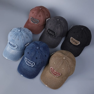 Dettaglio di sei cappellini da baseball in denim lavato con toppe vintage e ricami