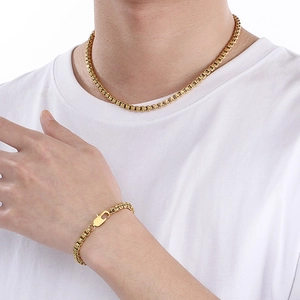 Golden stainless steel geometric pearl necklace and bracelet set worn by a model