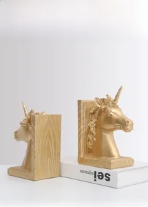 Detaillierte Nahaufnahme goldener Einhorn-Buchstützen mit Holzmaserung und Harztextur