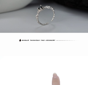 Detailed view of silver ring featuring lava texture and a black gemstone on a finger