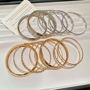 Gros plan de bracelets métalliques texturés montrant des designs lisses et torsadés