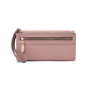 Close-up of litchi grain leather texture and gold leaf-shaped zipper on pink wallet