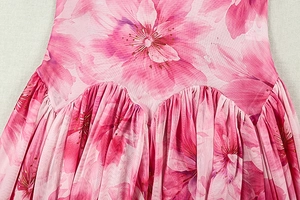 Détail d'une robe à imprimé floral rose avec taille plissée et tissu en mousseline