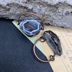 Pendentif géode d'agate vintage plaqué cuivre sur un fond de bois rustique naturel