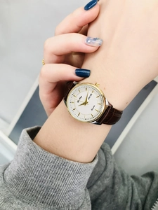 Close-up of a ladies' leather watch with white dial featuring day and date display