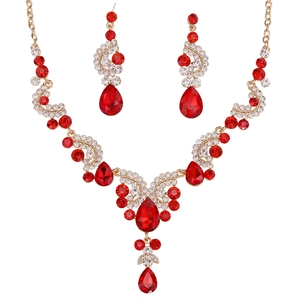 Detailed close-up of luxury bridal jewelry set with red teardrop gems and gold base