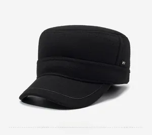 Detailed side view of black wool flat top military cap with small silver metal emblem