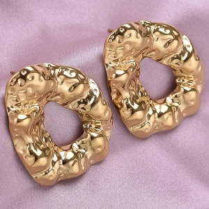 Macro detail of gold 304 stainless steel earrings with irregular hammered texture