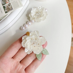 Elegante fermaglio per capelli a camelia bianca con lucentezza perlacea e foglie verdi