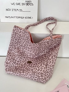 Fashionable leopard print canvas tote bag with metal plaque on white display stand