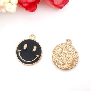 Detail of round smiley face charms with black enamel and textured gold metal back for DIY