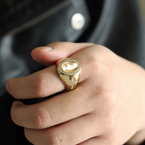 Detailed close-up of a gold Virgin Mary hip hop ring with cross and diamond accents