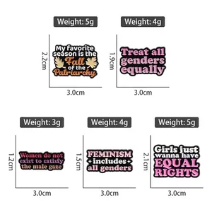 Fünf motivierende Emaille-Pins mit feministischen Slogans in Rosa und Schwarz auf Weiß